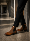 Brown leather shoes worn with black pants in an indoor setting